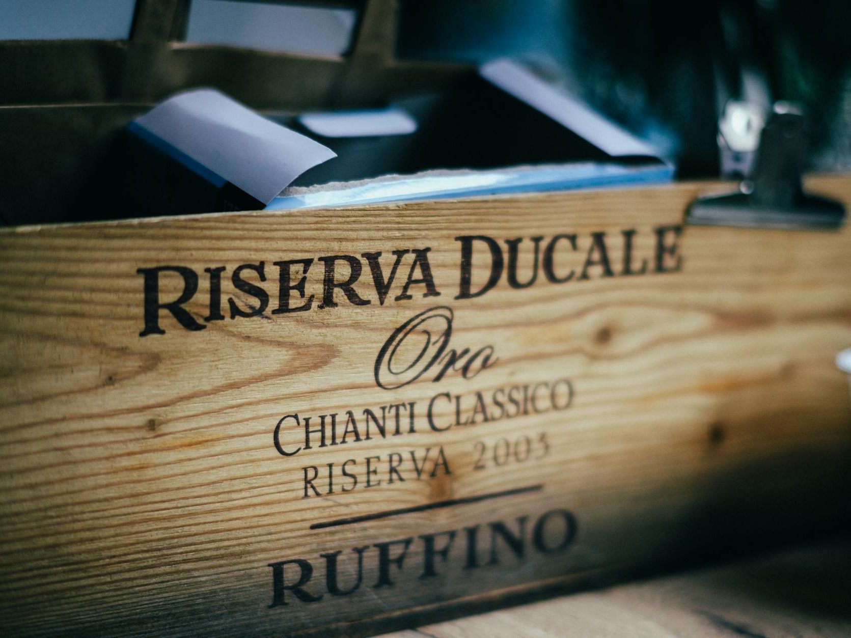 A close-up of a wooden wine box labeled 'Riserva Ducale Oro Chianti Classico Riserva 2005' from the Ruffino winery.